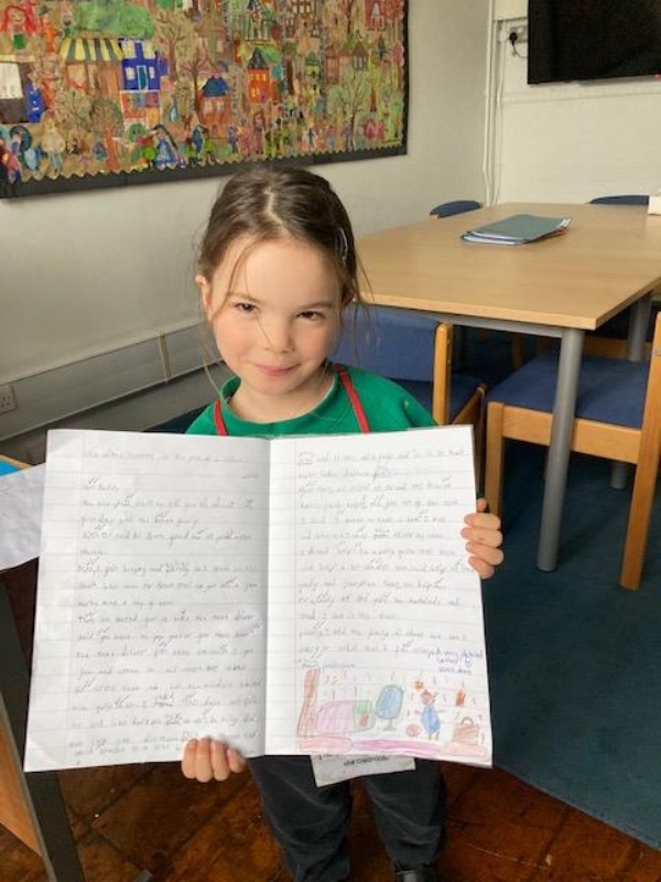 A very proud Year 1 child gets a Headteacher award for her amazing piece of writing